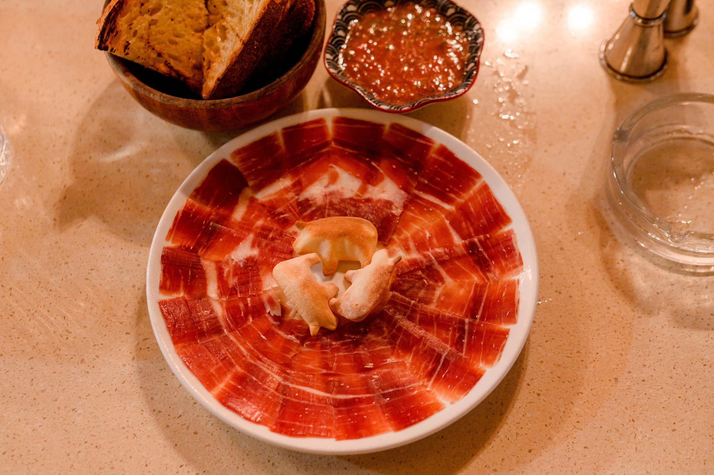 Jamón Ibérico de Bellota carved tableside with pan con tomate at IBÉRICO